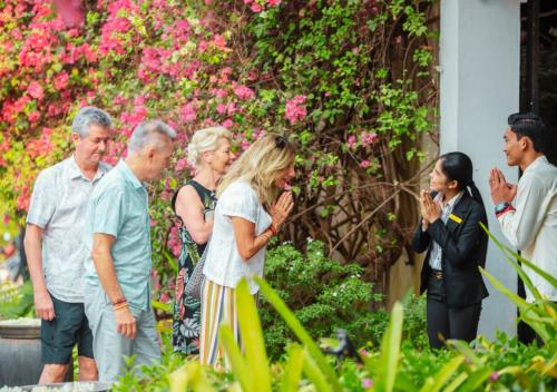 a group of people standing in front of a garden at Angkor Land House in Phumĭ Réach Born