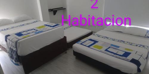 two beds in a room with the words haliden at Casa Quinta Santana in Melgar