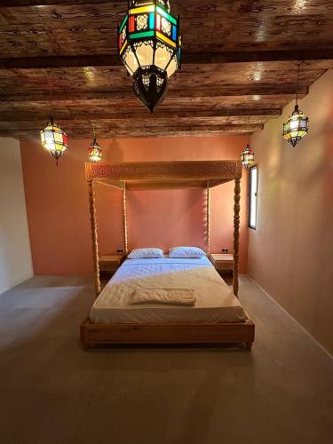 a bedroom with a wooden bed with a chandelier at STUDIO Dar Al-Fannan in Tangier