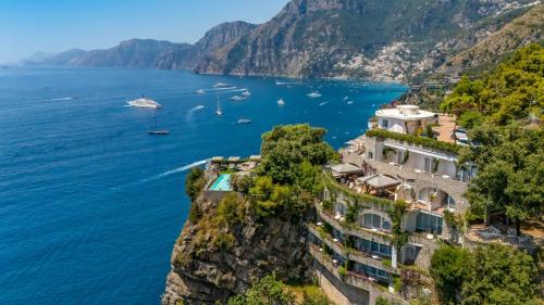 a building on a cliff next to the ocean at Hotel Piccolo Sant'Andrea in Praiano