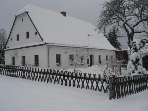 a house covered in snow next to a fence at Holiday Home in Zátor near Ještěd Ski Resort in Zátor