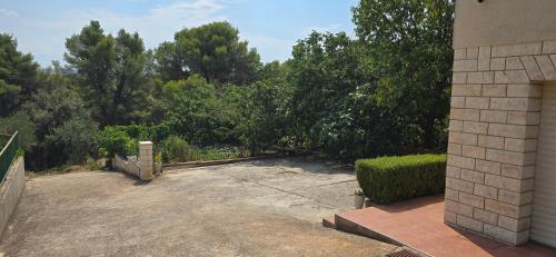 a backyard with a fence and trees in the background at Apartmani Deniza 2 guests in Brodarica