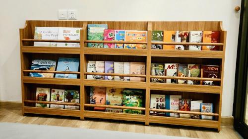 a wooden book shelf filled with books at Ecopark Lushy Stay - Vạt Xanh in Kim Quan