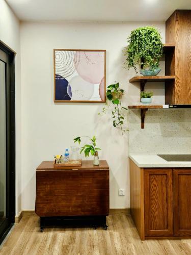 a kitchen with a wooden table and plants on the wall at Ecopark Lushy Stay - Vạt Xanh in Kim Quan