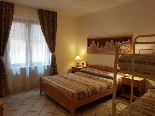 a bedroom with two bunk beds and a window at Casa Dorigoni Molveno in Molveno