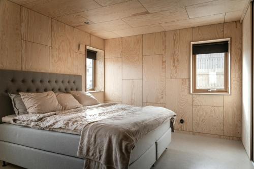 a bedroom with a bed and two windows at Kivikshusen in Kivik