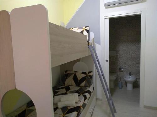 a bunk bed with a ladder in a bathroom at Avia in Lucera