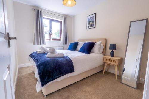 a bedroom with a bed with blue pillows and a mirror at 2 Bed, Ground Floor Flat, Carlisle in Carlisle