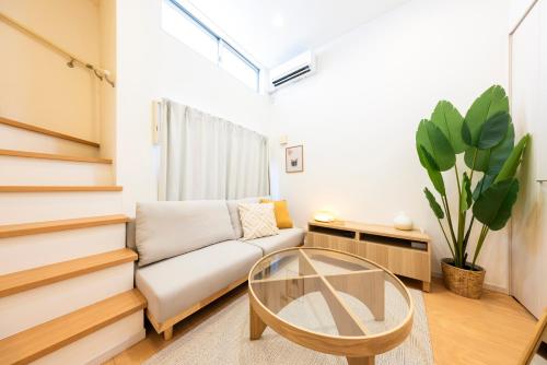 a living room with a white couch and a glass table at cocoloft Yoshizuka in Fukuoka