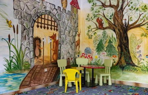 una stanza con un murale di un albero e delle sedie di Garden Szálláshely a Balatonszemes