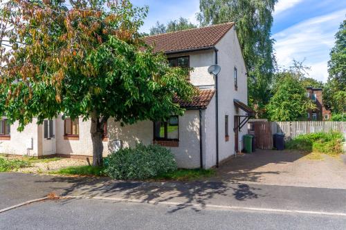 a white house with a tree in front of it at 2 Bed, Ground Floor Flat, Carlisle in Carlisle