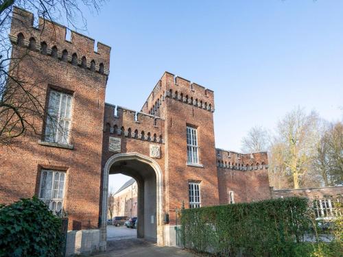 a large red brick building with an archway at Apartment in Kruibeke Wissekerke Castle in Kruibeke