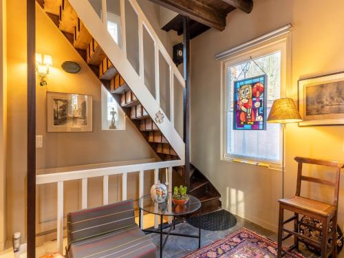 a living room with a spiral staircase and a table at Apartment in Kruibeke Wissekerke Castle in Kruibeke