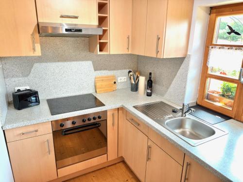 a kitchen with a sink and a stove top oven at Bayerwaldhaus - Tradition trifft Moderne in Waffenbrunn