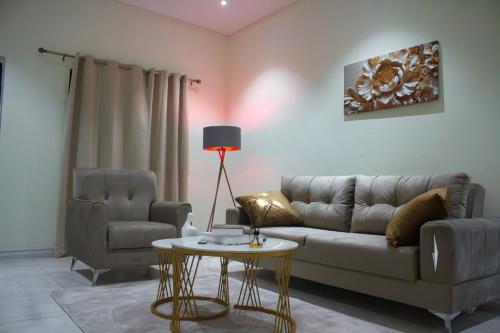 a living room with a couch and a table at Modern and Luxe Apartment in Kwabenya