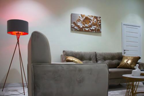 a living room with a couch and a lamp at Modern and Luxe Apartment in Kwabenya