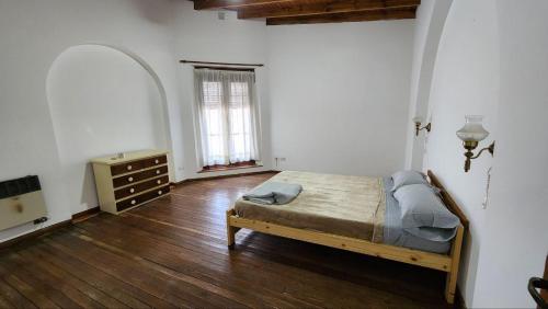 a bedroom with a bed and a dresser and a window at La casa de la abu in Carmen de Areco