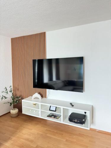 a white entertainment center with a flat screen tv on a wall at Apartman Latice in Tomislavgrad