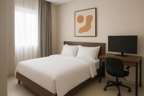 a bedroom with a bed and a desk with a computer at Damaibet in Jakarta