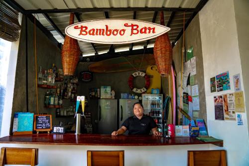 a man sitting at a bar in a barber shop at Bamboo Surf Beach in San Isidro