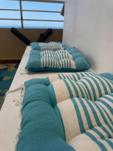 a row of pillows sitting on top of a bed at Location d'un appartement in Tizouiar