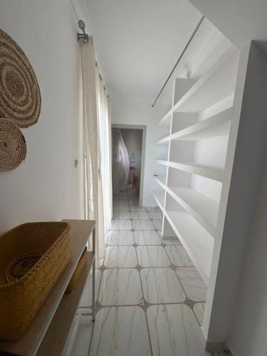 a white room with a staircase and a tiled floor at Location d'un appartement in Tizouiar