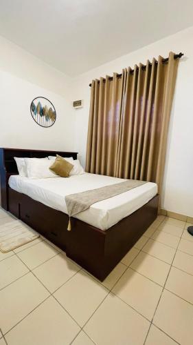 a bed in a room with a curtain at DK Lodge in Kandy