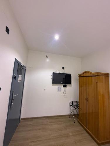 a room with a tv and a wooden cabinet at فندق نسيم الربيع in Muhayil