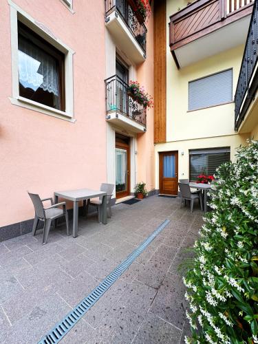 a patio with a table and chairs next to a building at Casa Dorigoni Molveno in Molveno