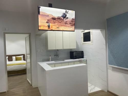 a kitchen with a sink and a tv hanging above it at فندق نسيم الربيع in Muhayil