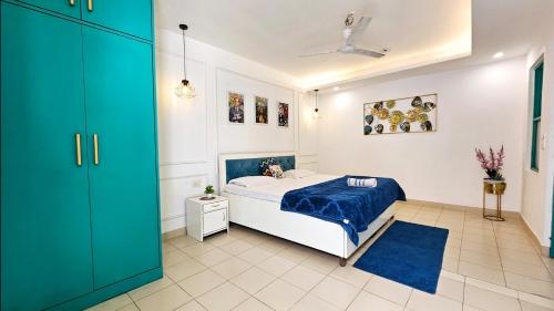 a bedroom with a bed and a blue cabinet at Mykonos Sky Penthouse Rooftop Pool 150" Cinema in Gurgaon