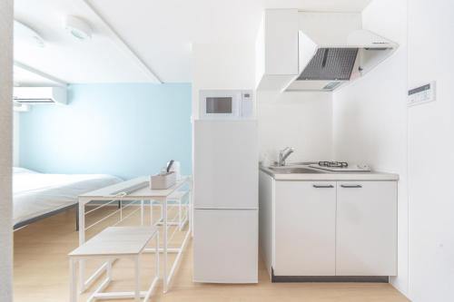 a white kitchen with a sink and a bed at TRUSS 2nd in Tokyo