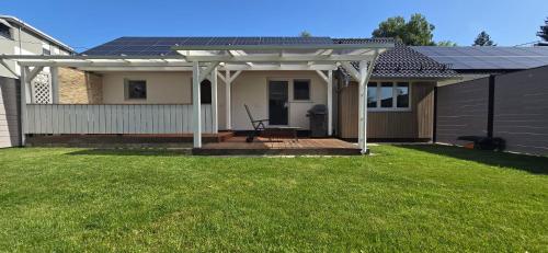 a house with a patio with a solar roof at FN Oak Bungalow in Friedrichshafen