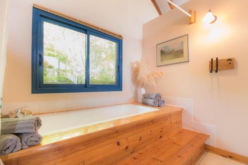 a bath tub in a bathroom with a window at וילה כפרית in Chorazim