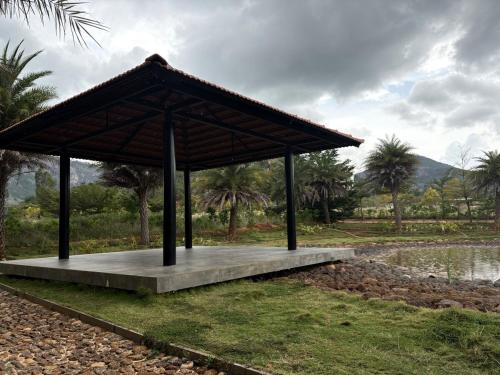a pavilion in a park next to a body of water at Green Cave Cozy Studio Room in Nandi