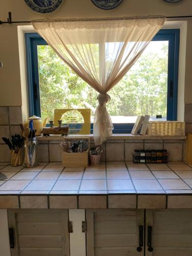 a kitchen with a window and a counter top at וילה כפרית in Chorazim