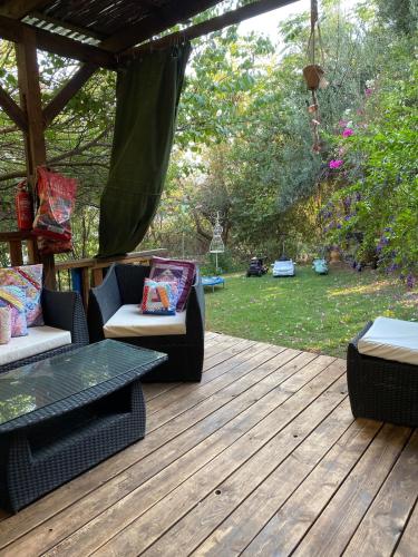 a patio with two chairs and a table on a deck at וילה כפרית in Chorazim