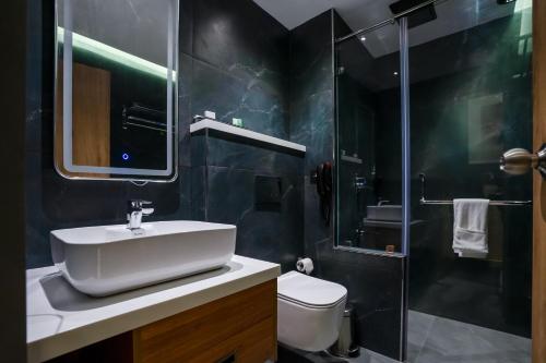 a bathroom with a sink and a shower and a toilet at Blue Moon Alleppey in Alleppey