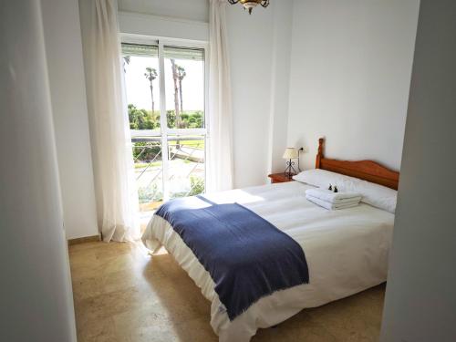a bedroom with a large bed and a window at Vista al Mar con Terraza - Costa Ballena Apartamento primera linea de playa in Costa Ballena