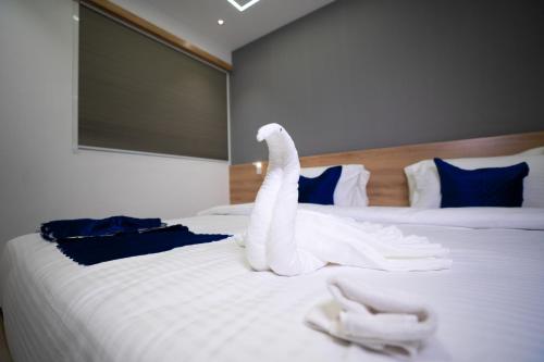 a swan is sitting on a white bed at Blue Moon Alleppey in Alleppey