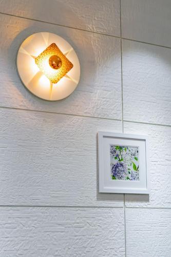 a light on a wall with a picture on it at Blue Moon Alleppey in Alleppey