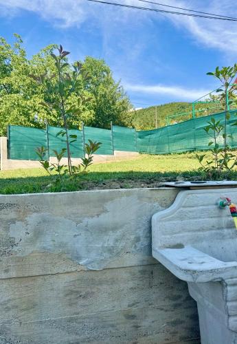 a concrete retaining wall with a green fence in the background at House Sarajka in Sarajevo