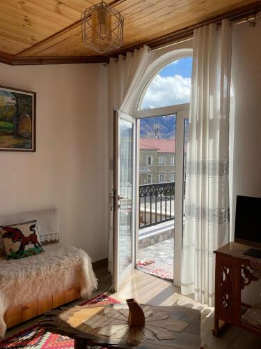 a bedroom with a large glass door with a balcony at As e vogël, As e madhe in Ersekë