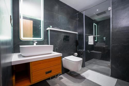 a bathroom with a sink and a toilet and a shower at Blue Moon Alleppey in Alleppey