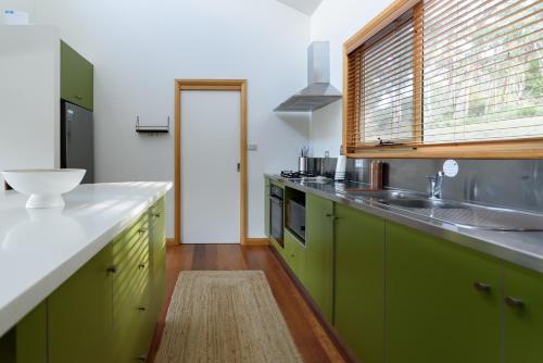 a kitchen with green cabinets and a sink at Scenic Getaway with Breathtaking Water Views in Gordon