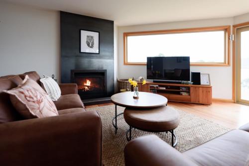 a living room with a couch and a table and a fireplace at Scenic Getaway with Breathtaking Water Views in Gordon