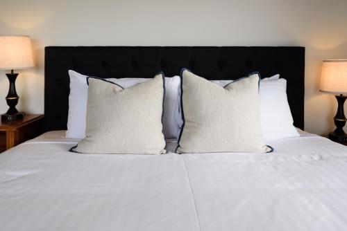 a white bed with white pillows and two lamps at Scenic Getaway with Breathtaking Water Views in Gordon