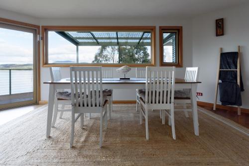 a white dining room table and chairs with a window at Scenic Getaway with Breathtaking Water Views in Gordon