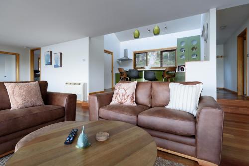 a living room with two brown couches and a table at Scenic Getaway with Breathtaking Water Views in Gordon