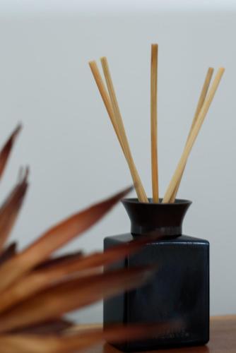 a black vase with bamboo sticks in it on a table at Scenic Getaway with Breathtaking Water Views in Gordon